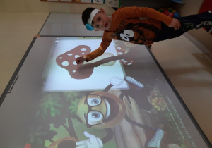 Dzieci rozwiązują zadania na tablicy interaktywnej