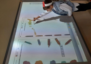 Przedszkolaki pracują z tablicą interaktywną