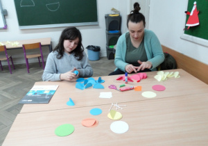 Uczniowie i rodzice w czasie tworzenia bombek z kolorowych kółek