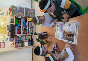 Dzieci oglądają książki o dinozaurach