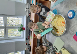 4. Chłopcy wrzucają pokrojone warzywa do miski