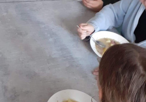 Uczniowie jedzą zupę