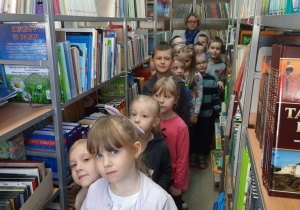 Dzieci oglądają książki w bibliotece szkolnej
