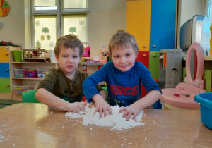 Chłopcy bawią się sztucznym śniegiem