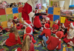 Mikołaj rozdaje dzieciom prezenty