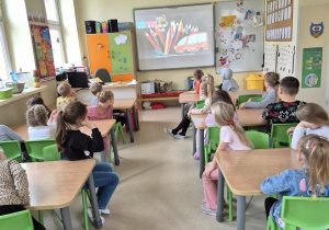 Dzieci oglądające film edukacyjny o kredkach