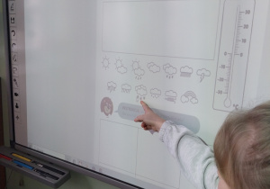 Uczennica rozwiązująca zadanie na tablicy interaktywnej