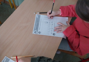 Dzieci rozwiązujące karty pracy