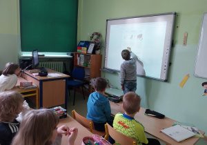 Uczeń rozwiązuje zadanie na tablicy interaktywnej.