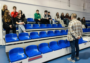 Uczniowie na hali sportowej z dyrektorem szkoły