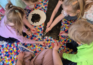 Dzieci malują pień drzewa