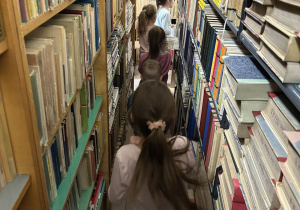Dzieci oglądają regały z książkami