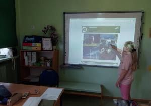 Uczennica rozwiązuje zadanie przy tablicy interaktywnej