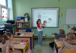 Uczennica prezentuje prawidłowy sposób mycia zębów