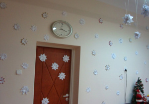 Świąteczne, białe gwiazdki z papieru zdobią ścianę i drzwi sali