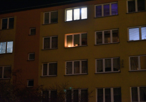Światełka świec zapalonych w oknach